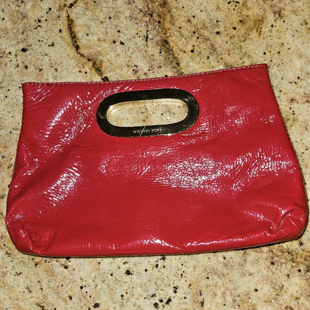 Retro 80s style Michael Kors red patent leather clutch with gold accents.
